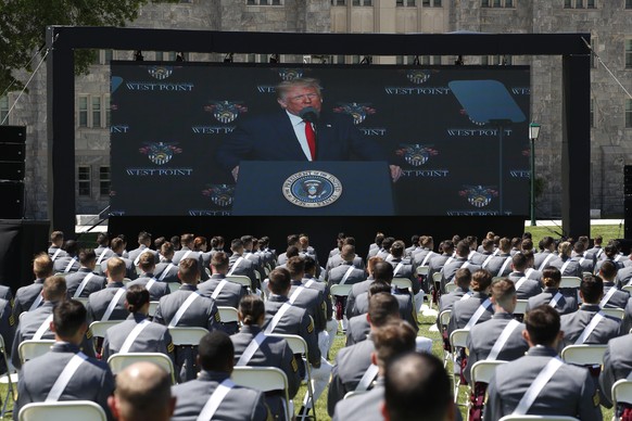 A screen displays President Donald Trump as he speaks to over 1,110 cadets in the Class of 2020 at a commencement ceremony on the parade field, at the United States Military Academy in West Point, N.Y ...