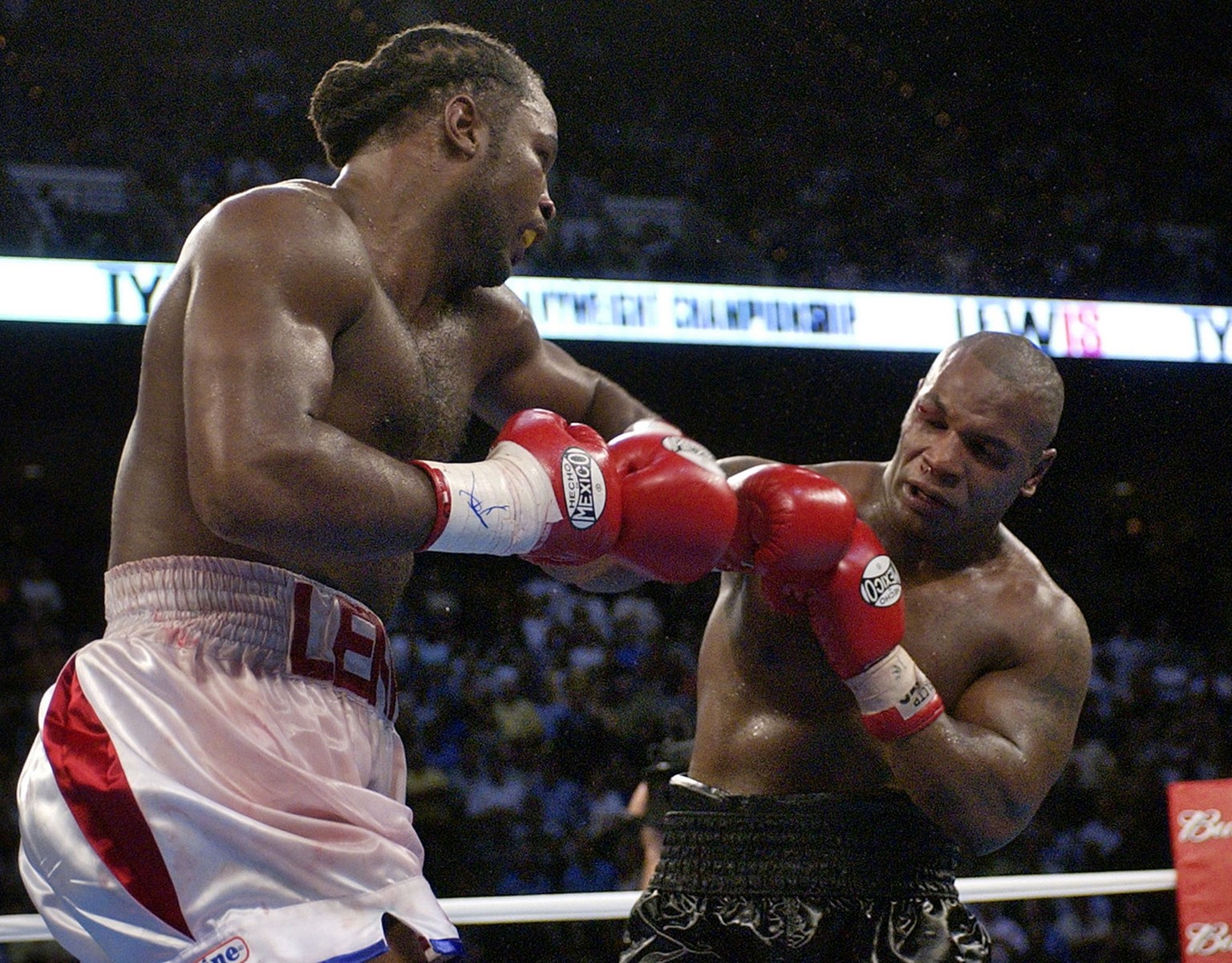 Lennox Lewis, left, goes after challenger Mike Tyson in the 8th round of their WBC/IBF heavyweight championship bout at The Pyramid in Memphis, Tenn., Saturday, June 8, 2002. Lewis was declared the wi ...