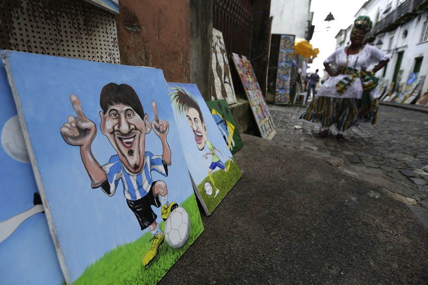 Paintings of soccer stars, Argentina&#039;s Lionel Messi, left, and Brazil&#039;s Neymar, are sold on the streets of the traditional neighborhood of Pelourinho, historical center of the city of Salvad ...