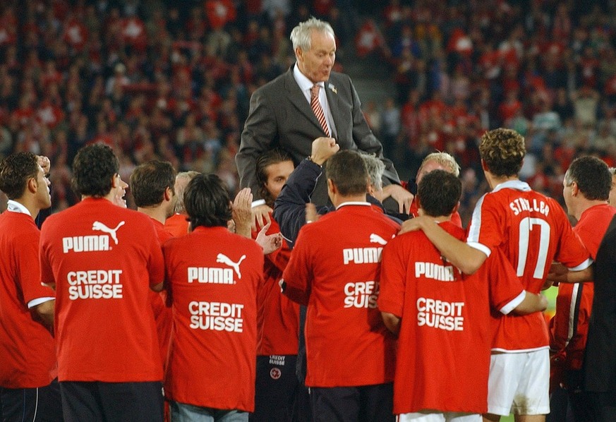 Swiss coach Jakob Kuhn, top, and his team celebrate the qualification for the EURO 2004 after the match between Switzerland and Ireland, at St. Jakob Park in Basel, Switzerland, Saturday, October 11,  ...