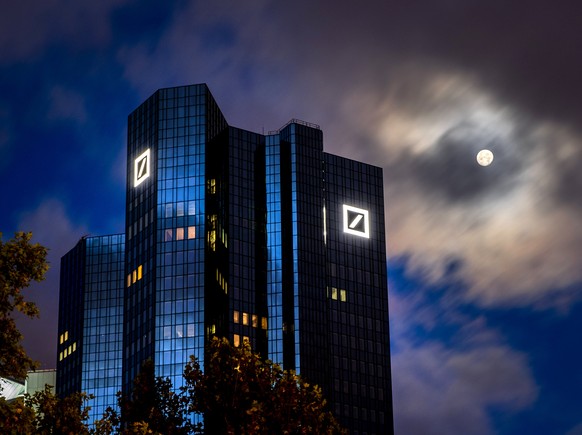 The moon shines next to the headquarters of the Deutsche Bank in Frankfurt, Germany, early Sunday, Oct. 4, 2020. (AP Photo/Michael Probst)