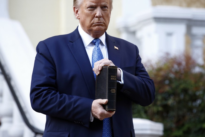 FILE - In this June 1, 2020, file photo, President Donald Trump holds a Bible as he visits outside St. John&#039;s Church across Lafayette Park from the White House in Washington. Part of the church w ...