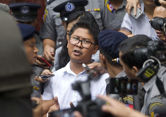 Reuters journalist Wa Lone, center, talks to journalists during he is escorted by polices as they leave the court Monday, Sept. 3, 2018, in Yangon, Myanmar. A Myanmar court sentenced two Reuters journ ...