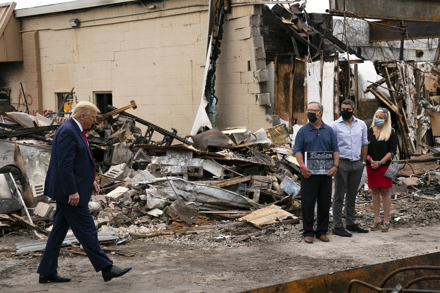 President Donald Trump walks over to talk to business owners Tuesday, Sept. 1, 2020, as he tours an area damaged during demonstrations after a police officer shot Jacob Blake in Kenosha, Wis. (AP Phot ...