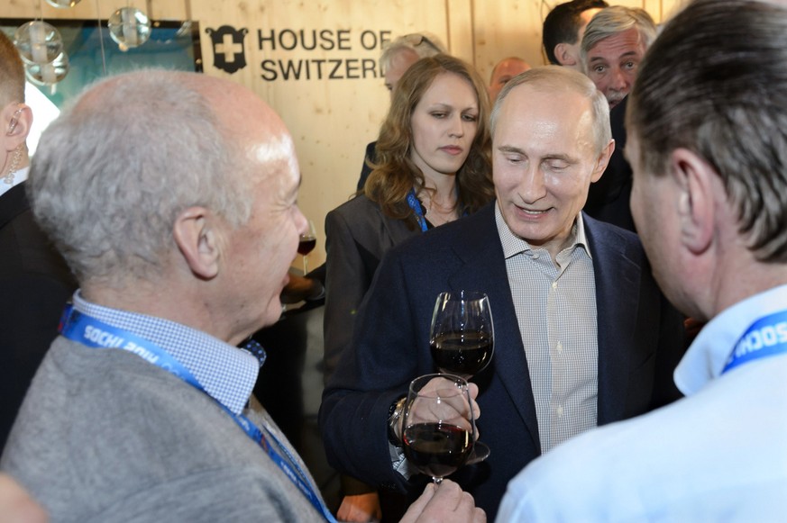 Russian President Vladimir Putin, right, and Swiss Federal Councillor Ueli Maurer, left, cheer with red wine during his visit at the House of Switzerland, HoS, in the Olympic Park at the XXII Winter O ...