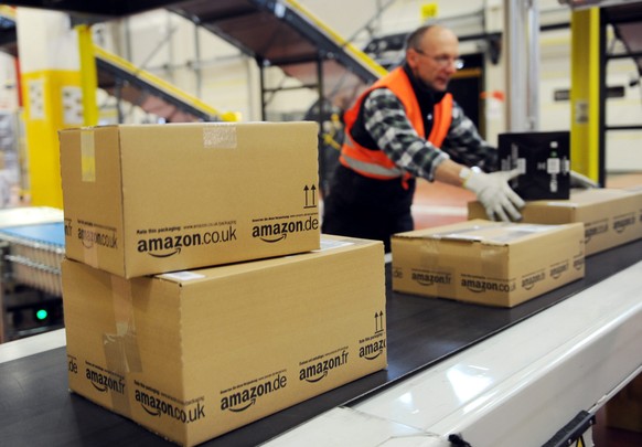 epa04329826 (FILE) A file photo dated 20 December 2010 showing an employee of the online-retailer Amazon putting packages onto a conveyor band at the logistics centre in Bad Hersfeld, Germany. Amazon  ...