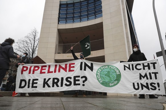 epa08932496 Environmental activists from the Fridays For Future (FFF) and Ende Gelaende movements hold a placard reading &#039;Pipeline into the crisis?&#039; during a demonstration in front of the So ...