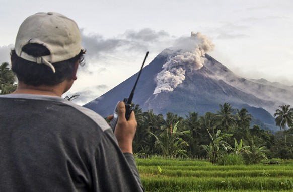 A volunteer uses his walkie talkie as he monitors Mount Merapi during an eruption in Sleman, Wednesday, Jan. 27, 2021. Indonesia&#039;s most active volcano erupted Wednesday with a river of lava and s ...