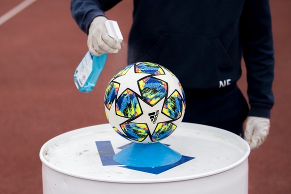 Un ramasseur de balle desinfecte un ballon lors du quart de final de la Coupe de Suisse de football entre le FC Lausanne-Sport, LS et le FC Basel 1893 le dimanche 14 juin 2020 au stade olympique de la ...