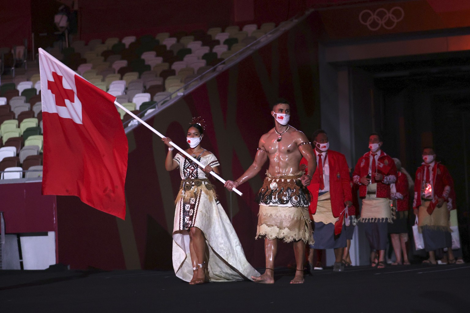 Malia Paseka and Pita Taufatofua, of Tonga, carry their country&#039;s flag during the opening ceremony in the Olympic Stadium at the 2020 Summer Olympics, Friday, July 23, 2021, in Tokyo, Japan. (Han ...