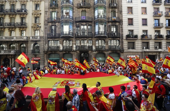 epa06253058 Protestors carry a giant Spanish flag during a rally in favour of the unity of Spain in Barcelona, Spain, 08 October 2017. The march organised by the &#039;Societat Civil Catalana&#039; (C ...