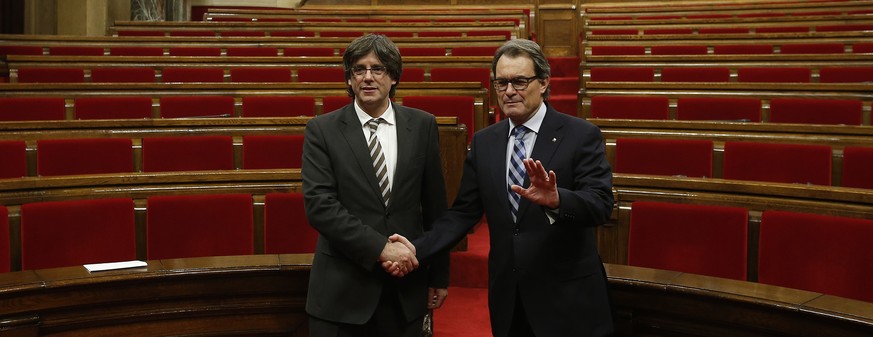 Der neue und der alte Ministerpräsident Kataloniens: Carles Puigdemont (links, neu) und Artur Mas (rechts, alt) reichen sich die Hand.