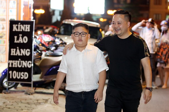 epa07383010 To Gia Huy, nine-years-old (L) walks with his father after having North Korean leader Kim Jong-un haircut style, at a street of Hanoi, Vietnam, 20 February 2019. Le Tuan Duong, the owner o ...