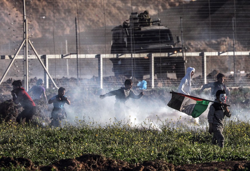 epa07423409 Palestinian protesters run for cover after Israeli troops open fire during clashes after Friday protests near the border between Israel and Gaza Strip, east Gaza, 08 March 2019. Young, 18- ...