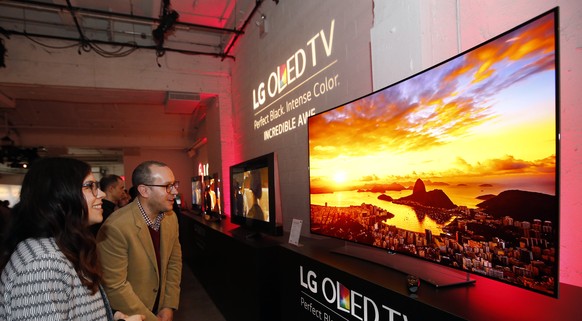 IMAGE DISTRIBUTED FOR LG ELECTRONICS - Attendees marvel at an LG Curved 4K UHD OLED TV (Model 65EG9600) at LG and Netflix’s Dare to See OLED event, Wednesday, April 8, 2015 in New York. (Photo by Jaso ...