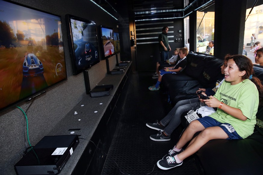 IMAGE DISTRIBUTED FOR XBOX - Inside large game trucks parked at Boys &amp; Girls Club of Santa Monica, kids try their hand at racing in “Forza Horizon 2” for Xbox One on Tuesday, Sept. 30, 2014 in San ...