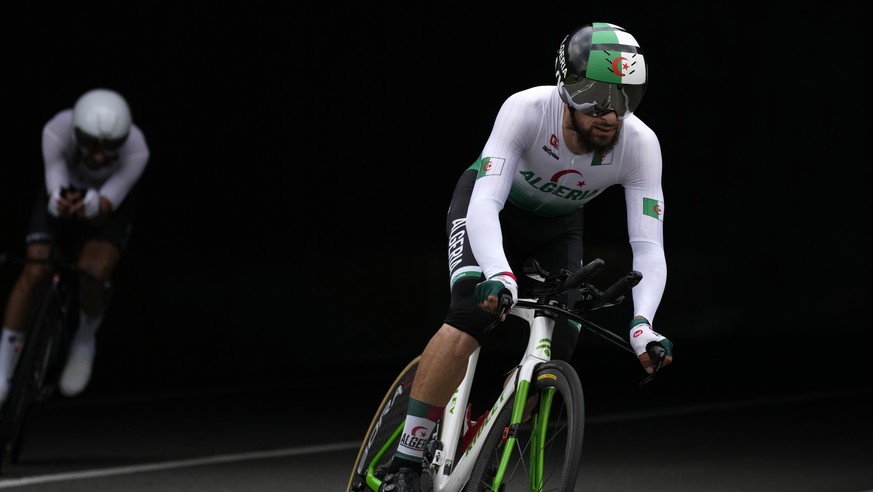 Azzedine Lagab of Algeria, right, and Ahmad Badreddin Wais of the Olympic Refugee Team, compete during the men&#039;s cycling individual time trial at the 2020 Summer Olympics, Wednesday, July 28, 202 ...