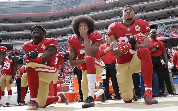 FILE - In this Oct. 2, 2016 file photo, from left, San Francisco 49ers outside linebacker Eli Harold, quarterback Colin Kaepernick and safety Eric Reid kneel during the national anthem before an NFL f ...