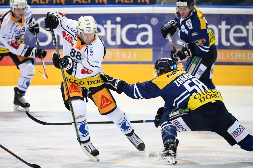 Zug&#039;s player Sven Senteler, left, fights for the puck with Ambri&#039;s player Jesse Zgraggen, right, during the preliminary round game of National League A (NLA) Swiss Championship 2016/17 betwe ...