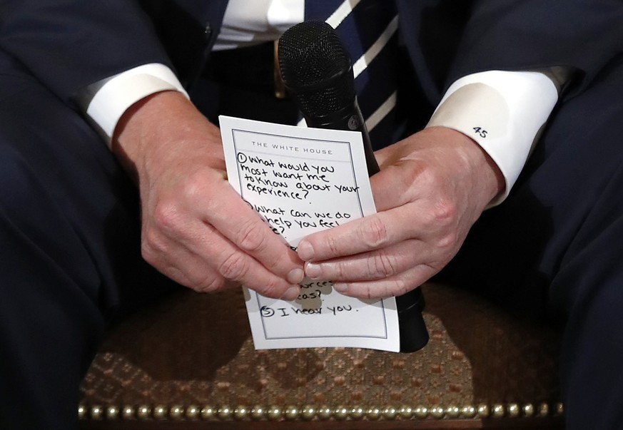 President Donald Trump holds notes during a listening session with high school students and teachers in the State Dining Room of the White House in Washington, Wednesday, Feb. 21, 2018. Trump heard th ...