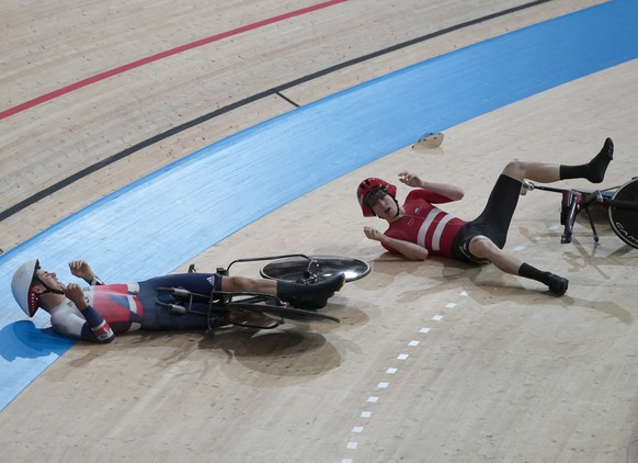 epa09390047 Frederik Madsen (R) of Denmark crashes with Charlie Tanfield (L) of Great Britain during the Men&#039;s Team Pursuit first round during the Track Cycling events of the Tokyo 2020 Olympic G ...