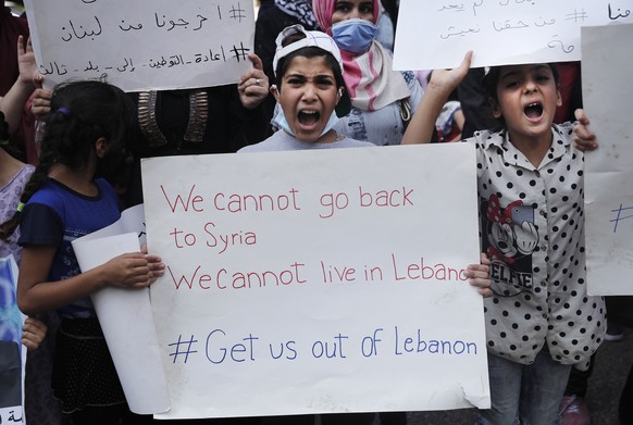 Syrian refugees shout slogans as they protest outside the headquarters of the United Nations refugee agency, UNHCR, demanding to be moved out of Lebanon which is undergoing its worse economic crisis i ...