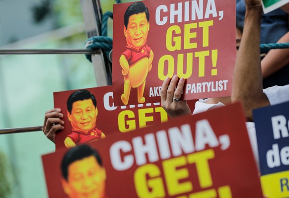 epaselect epa07180652 Activists hold placards with the image of Chinese President Xi Jinping as &#039;Winnie the Pooh&#039; during a protest at the Chinese Embassy in Manila, Philippines, 21 November  ...