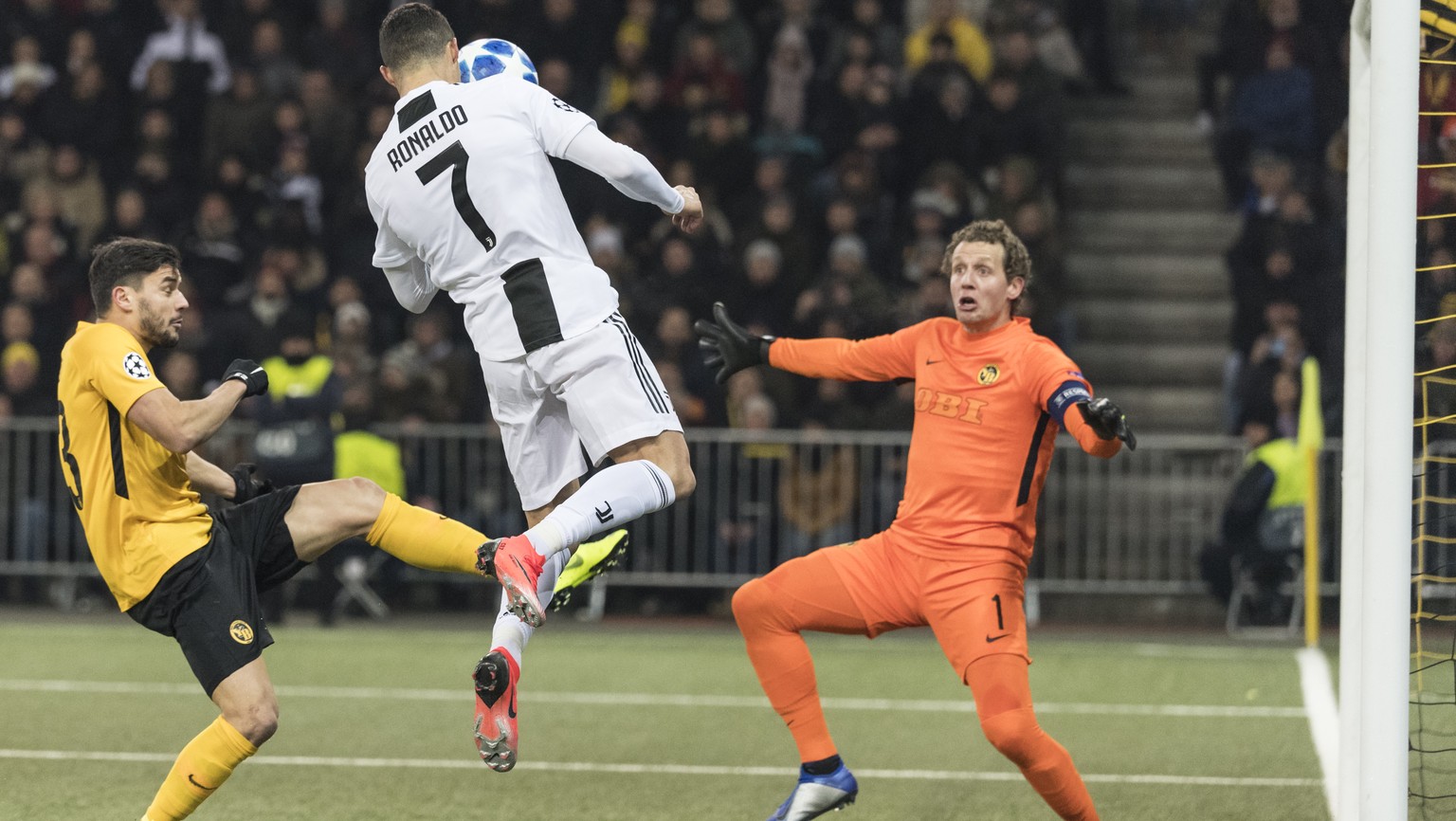 Juventus&#039; Cristiano Ronaldo, center, tries a header against Young Boys&#039; goalkeeper Marco Woelfli and Loris Benito, during the UEFA Champions League group stage group H matchday 6 soccer matc ...