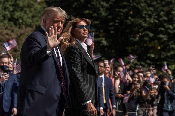 epa08706558 US President Donald J. Trump and First lady Melania Trump wave to supporters as they walk across the South Lawn to Marine One at the White House in Washington, DC, USA, 29 September 2020.  ...