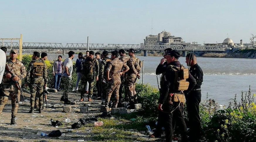 epa07453787 Soldiers near the site where an overloaded ferry sank in the Tigris river near Mosul, Iraq, 21 March 2019. According to reports, more than 70 people drowned after an overloaded ferry sank  ...