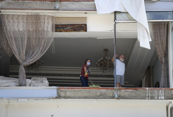 A woman cleans debris from her damaged apartment a day after an explosion hit the seaport of Beirut, Lebanon, Wednesday, Aug. 5, 2020. Residents of Beirut confronted a scene of utter devastation on We ...