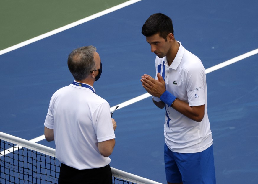 epa08651691 Novak Djokovic of Serbia (R) talks to Head of Officiating at International Tennis Federation (ITF) Soeren Friemel after he accidentally hit a linesperson with a ball in the throat during h ...