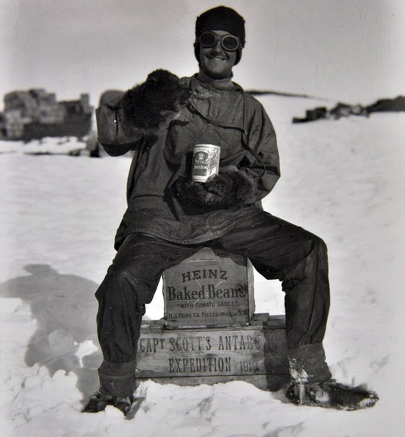 Frederick Hooper isst eine Dose Bohnen, auf einer Heinz-Box sitzend, 1911. Er muss mit der Motorenabteilung am 21. November zur Terra-Nova-Hütte zurückkehren.