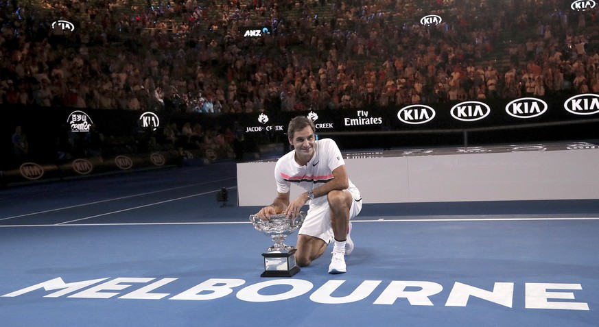 Switzerland&#039;s Roger Federer poses with his trophy after defeating Croatia&#039;s Marin Cilic in the men&#039;s singles final at the Australian Open tennis championships in Melbourne, Australia, S ...