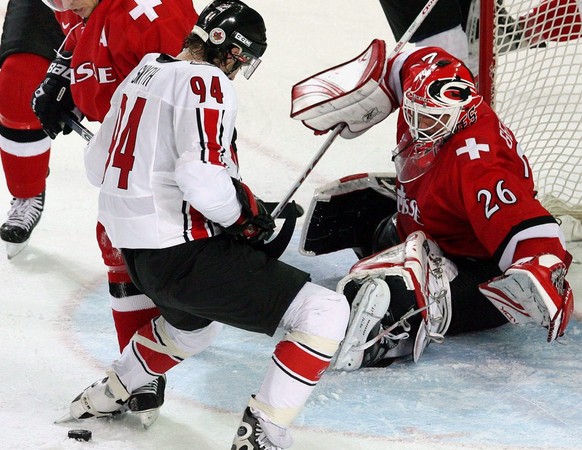Switzerland&#039;s Martin Gerber (R) stop Canada&#039;s Ryan Smith (C) in front of the net during the Men&#039;s Preliminary Round game between Canada and Switzerland at the Turin 2006 Winter Olympic  ...