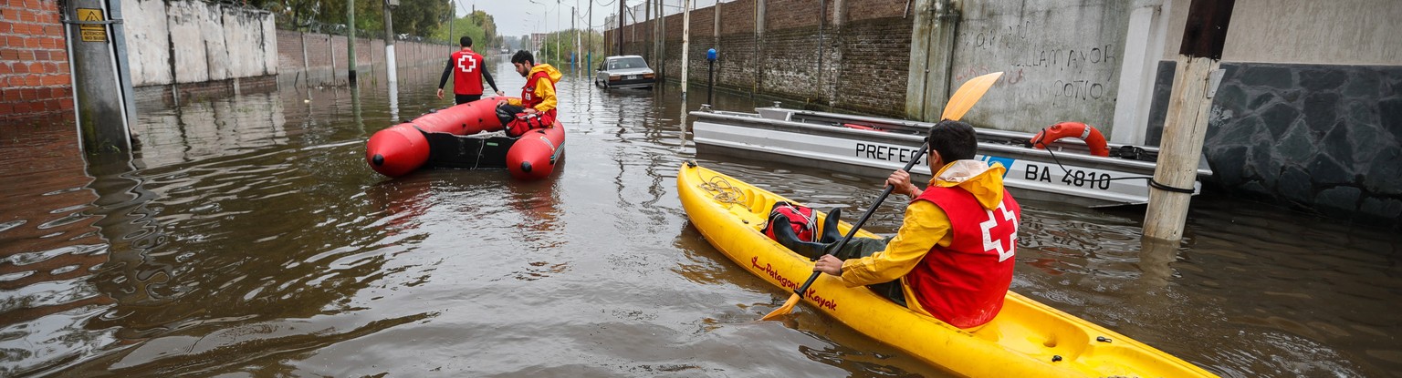 epa07925886 Rescue workers move in an emergency boat in search of people affected by floods at the Esteban Echeverria area, in the province of Buenos Aires, Argentina, 16 October 2019. Localities in t ...