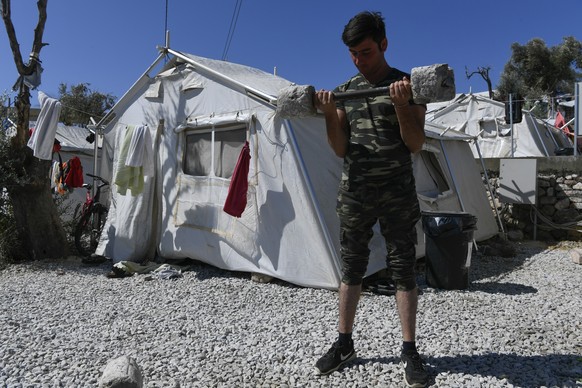 Afghan migrant Esmail Mohammadi, 29, lifts weights outside the Moria refugee camp, on the northeastern Aegean island of Lesbos, Greece, Saturday, Sept. 21, 2019. A perpetually overcrowded refugee camp ...