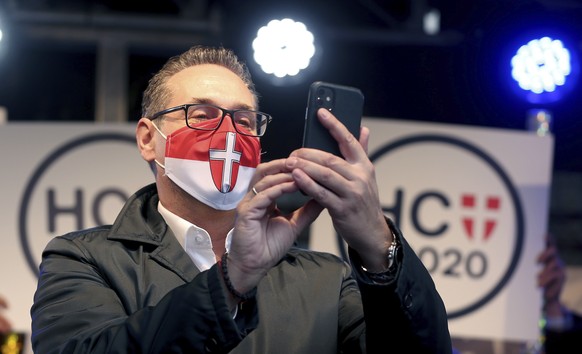 Heinz-Christian Strache with face mask, former leader of the right-wing Freedom Party, FPOE, looks at his cellphone at a closing rally for his party Team Strache ahead to the local elections in Vienna ...