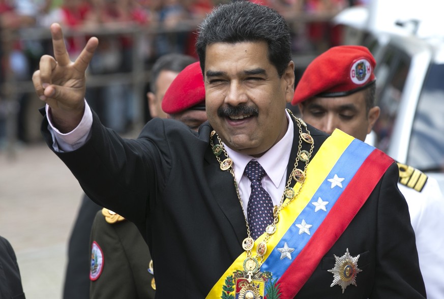 Venezuela&#039;s President Nicolas Maduro flashes a victory sign to supporters as he arrives to the Supreme Court to deliver his annual state of the nation report in Caracas, Venezuela, Sunday, Jan. 1 ...