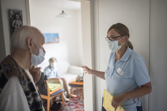 Die Spitex Pflegefachfrau Helene Widrig spricht mit dem Mann einer Kundin, aufgenommen waehrend der Coronavirus-Pandemie, am Mittwoch, 20. Mai 2020, in Wittenbach. (KEYSTONE/Gian Ehrenzeller)