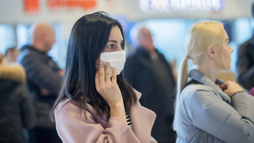 epa08246746 A woman wearing a protective mask is waiting for arriving passengers at airport of Chisinau, Moldova, 25 February 2020. Moldova&#039;s government decided to increase border crossing contro ...