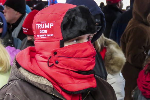 epa08080379 People stand in 17 degree (-8.33C) temperatures waiting to hear US President Donald J. Trump speak at his Christmas Rally at the Kellogg Arena in Battle Creek, Michigan, USA 18 December 20 ...