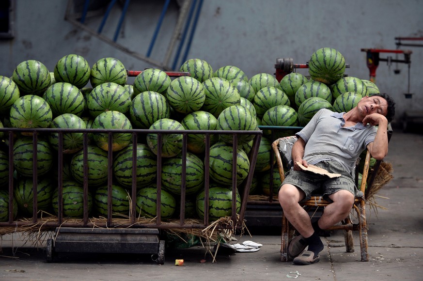 A vendor selling watermelons naps as he waits for customers at a market in Taiyuan, Shanxi province, July 17, 2013. REUTERS/Jon Woo/File Photo GLOBAL BUSINESS WEEK AHEAD PACKAGE - SEARCH &quot;BUSINES ...