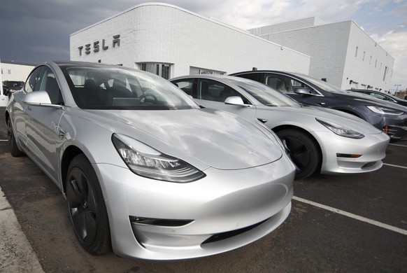 FILE- In this July 8, 2018, file photo, 2018 Model 3 sedans sit on display outside a Tesla showroom in Littleton, Colo. On Thursday, Aug. 9, Tesla shares have dropped back to near the level they were  ...