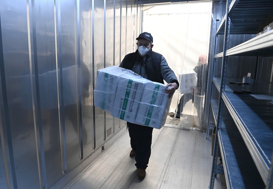 epa09104426 An employee unloads the newly arrived coronavirus vaccines from Chinese pharmaceutical company Sinopharm at the logistics base set up to in the parking lot of the government office in the  ...
