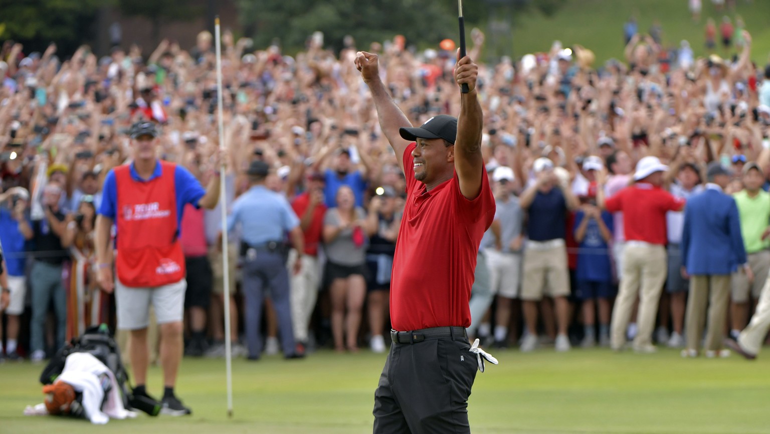 Tiger Woods celebrates after picking up his putt for par on the 18th green to win the final round of the Tour Championship golf tournament Sunday, Sept. 23, 2018, in Atlanta. (Hyosub Shin/Atlanta Jour ...