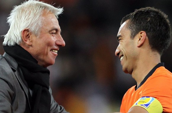 epa02239307 Coach of the Netherlands, Bert van Marwijk and player Giovani van Bronckhorst celebrate after the FIFA World Cup 2010 semi final match between Uruguay and Netherlands at the Green Point st ...
