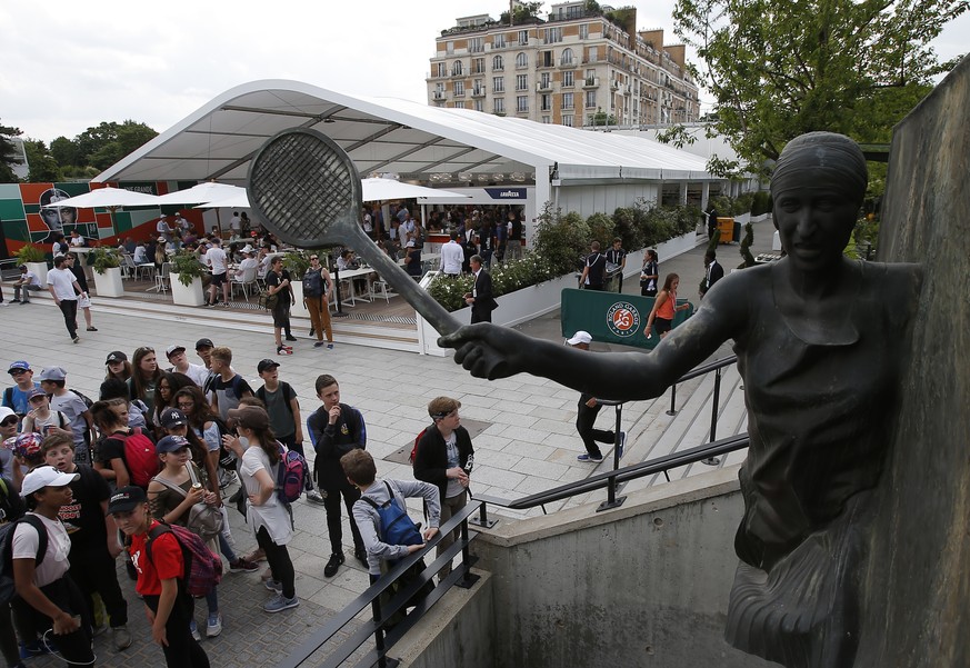 Children watch the statue of late French tennis champion Suzanne Lenglen at the Roland Garros stadium in Paris, Friday, May 25, 2018. The French Open tennis tournament starts Sunday. (AP Photo/Michel  ...