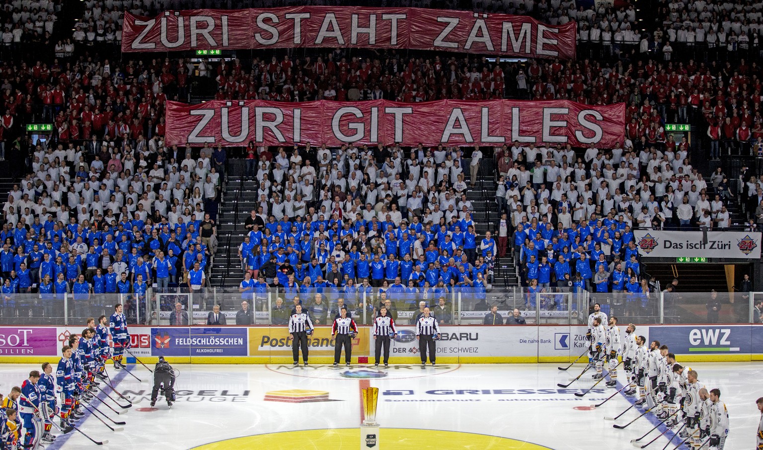 Die Spieler, Schiedsrichter und Zuschauer stehen waehrend die Schweizer Nationalhymne gespielt wird vor dem sechsten Eishockey Playoff-Finalspiel der National League zwischen den ZSC Lions und dem HC  ...