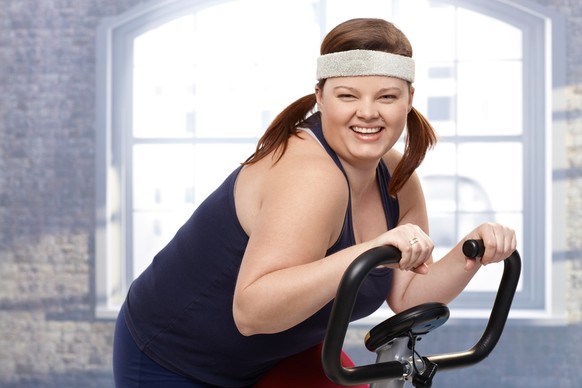 Happy fat woman training on exercise bike, smiling.
Amerika fitnessstudio dick
